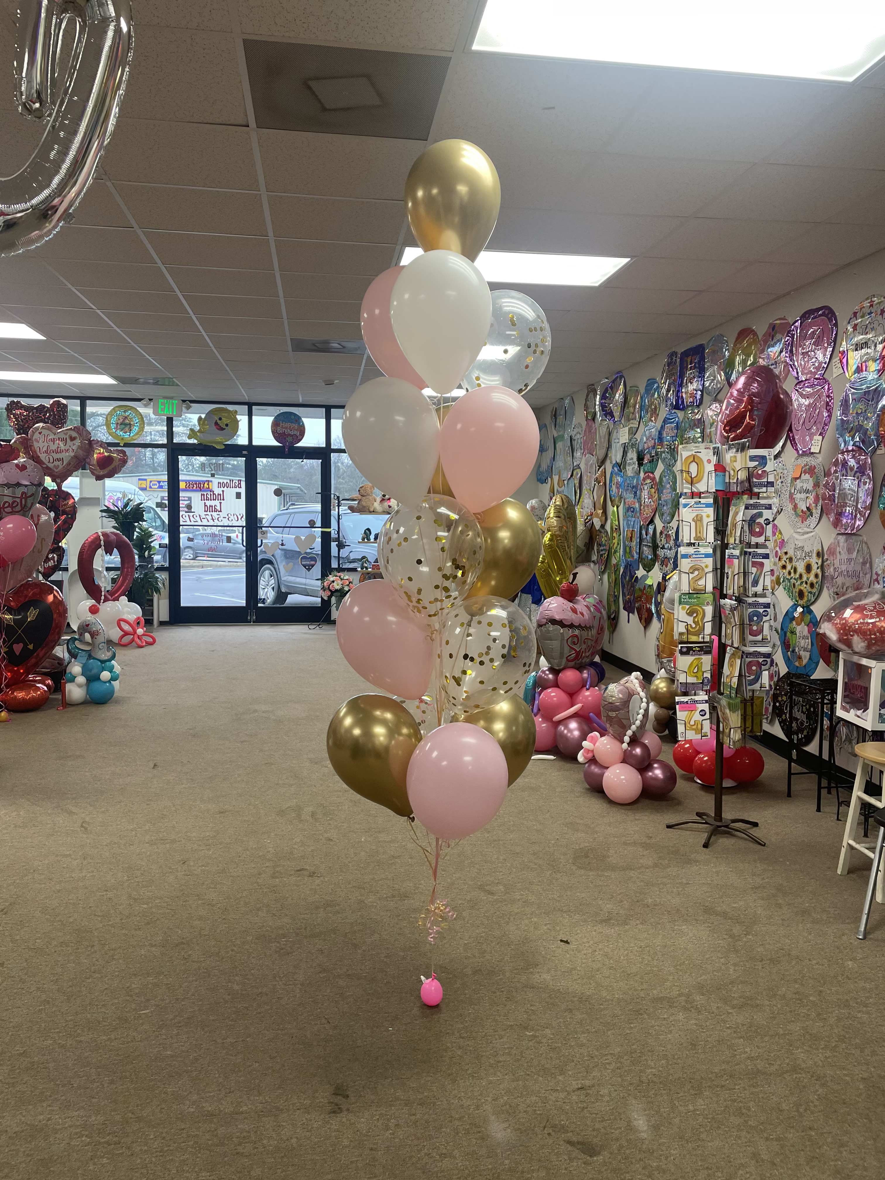 Cluster of pink, white, and gold balloons in a party store
