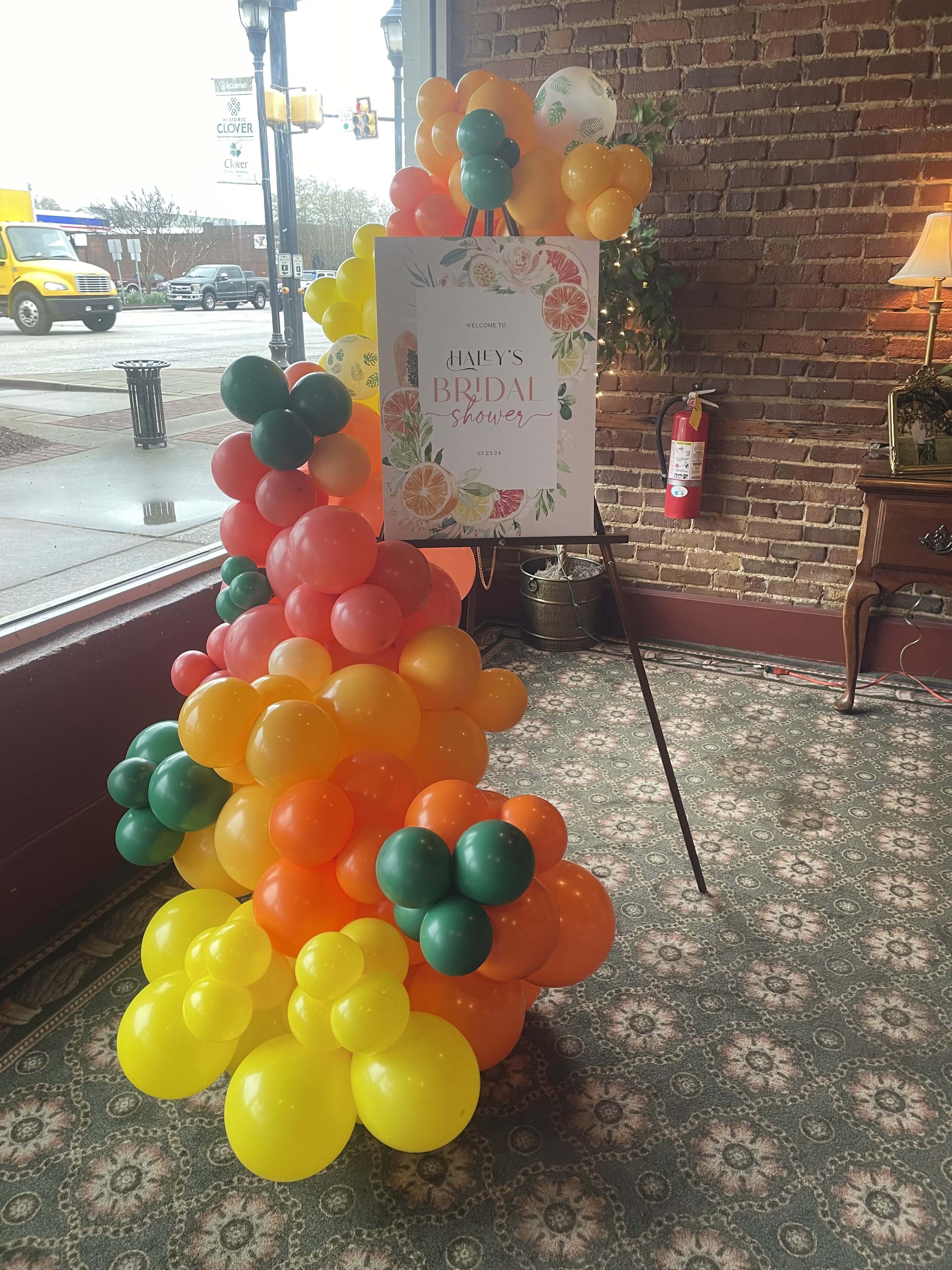 Colorful balloon arch beside a bridal shower sign