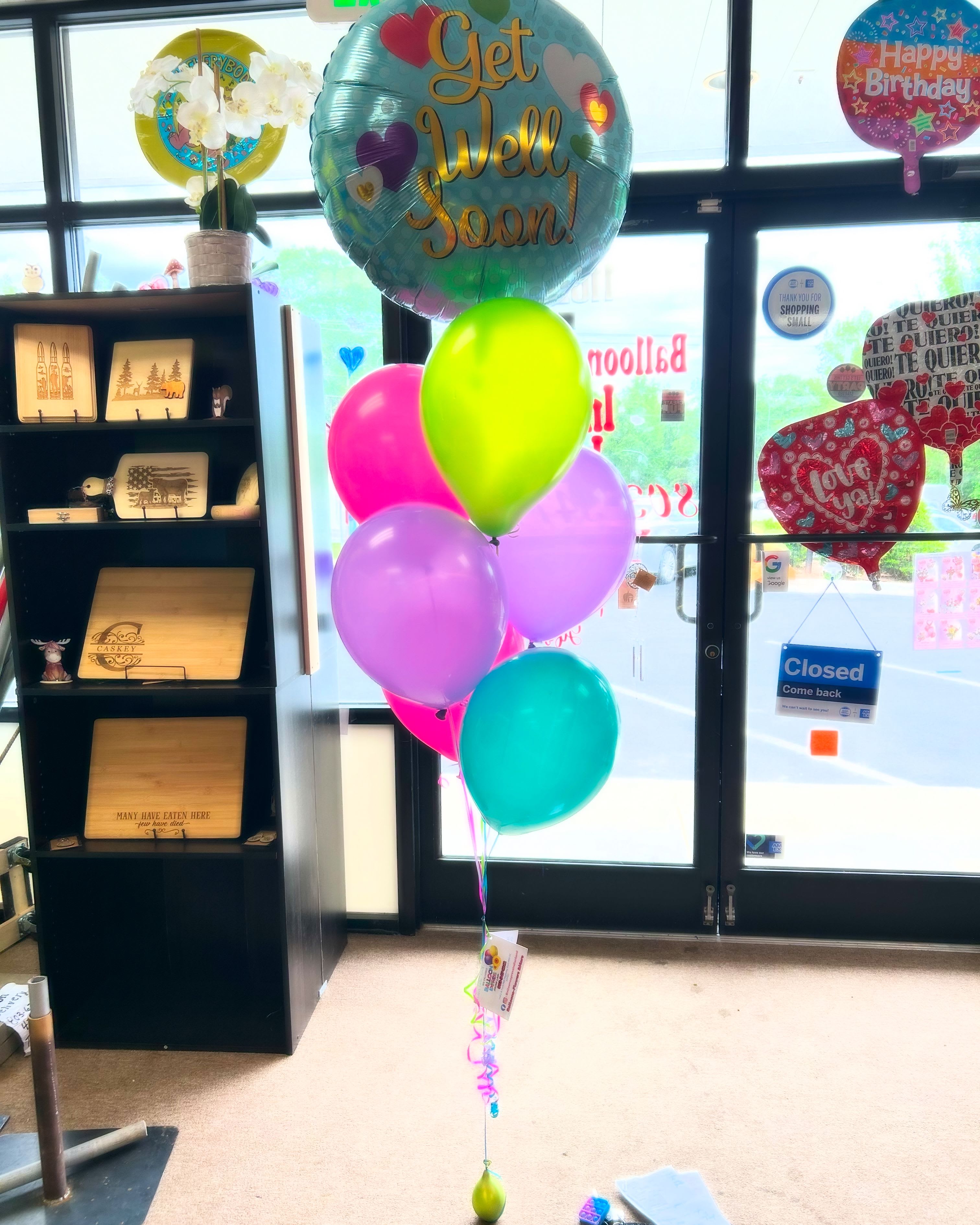 Cluster of colorful birthday and get well balloons in a store entrance