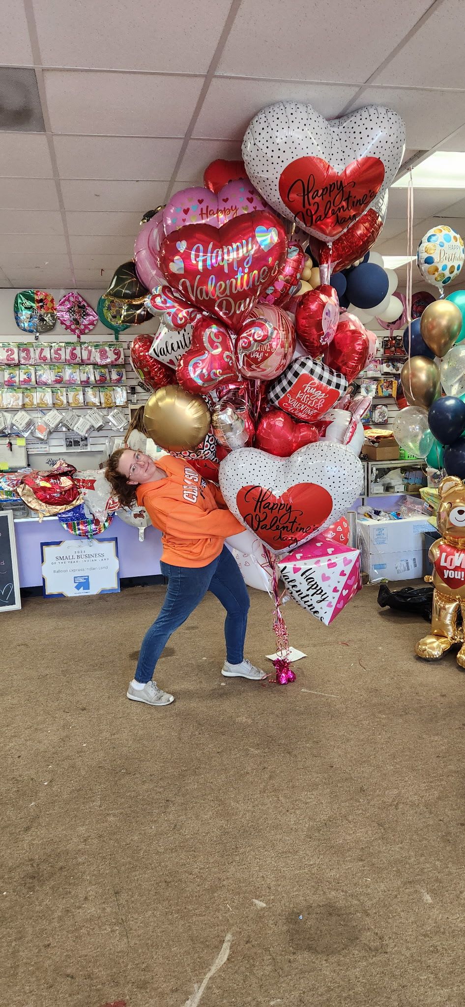 Large cluster of heart-shaped Valentine balloons in red, white, pink, and gold