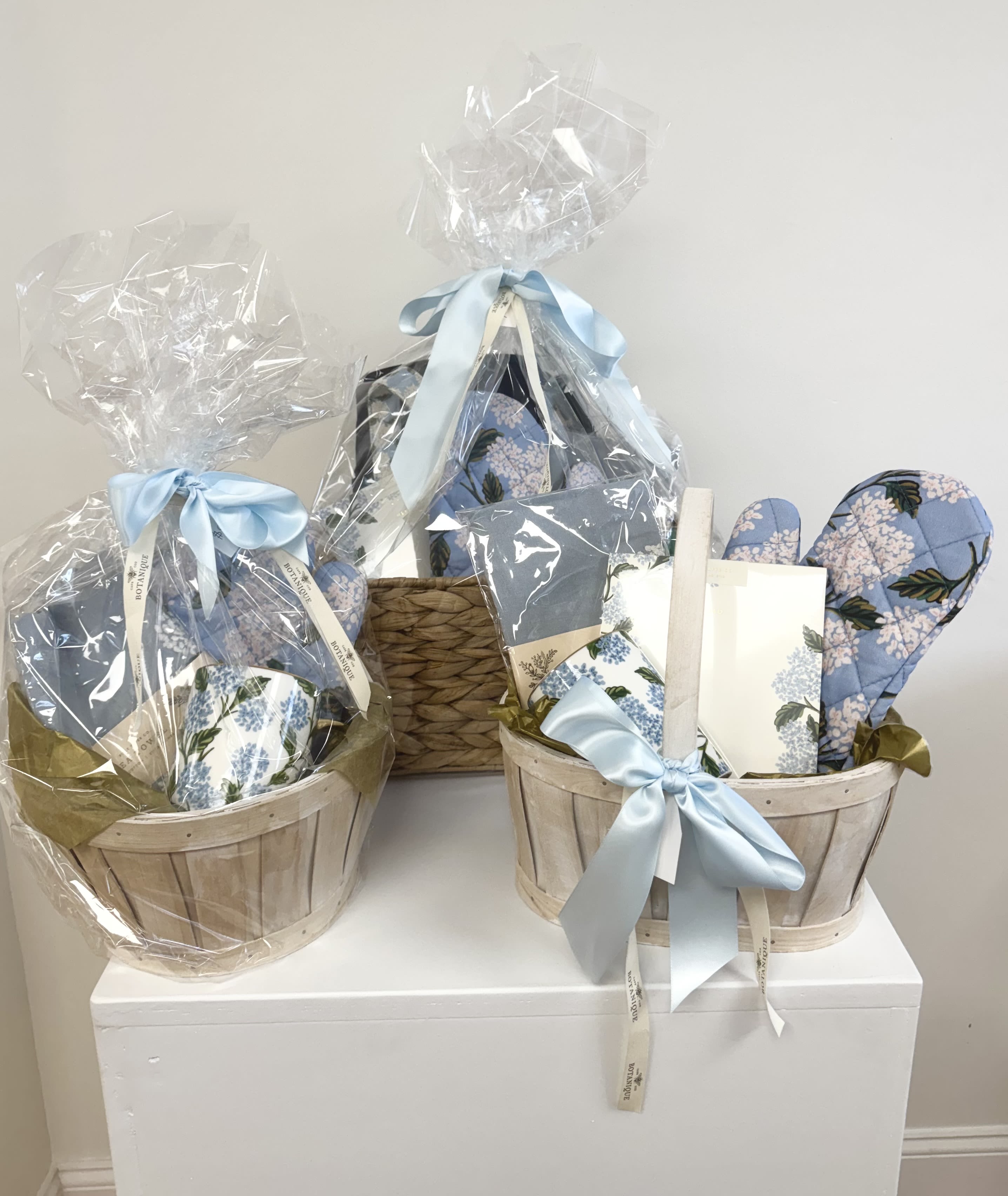 Hydrangea Lover's Gift Basket - These beautifully curated baskets include hydrangea-inspired gifts such as tea towels, mugs, oven mitts, canvas tote bags, and stationery.  Each basket is unique, feel free to call and request specific items (based on availability) or simply let our designers choose the perfect combination.   Please note that all three price points are pictured here.