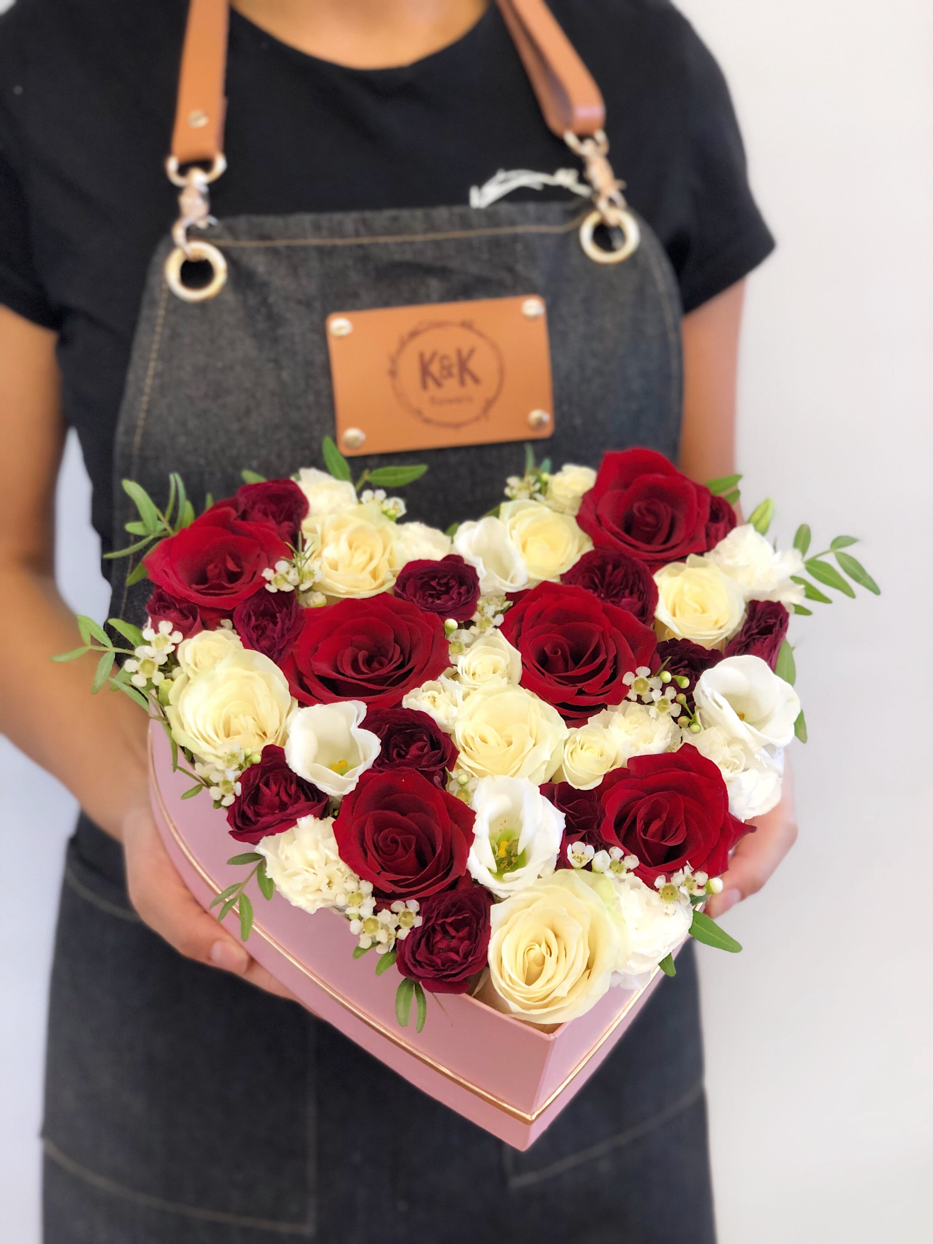 Heart Shaped Box Red And White - Heart-shaped box filled with roses and spray roses. Flowers in boxes don’t need vases. That makes it perfect for transportation and keeping flowers hydrated and secure.