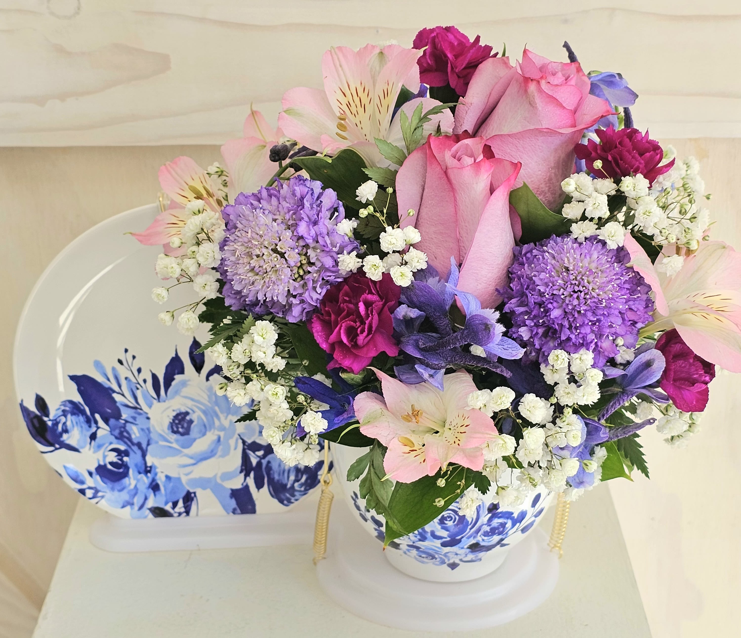 Blue Tea Cup - Set includes the blue tea cup, the saucer, and the display tray. This set is designed in a variety of  lilacs, purples and blues. Flower variety may vary. 