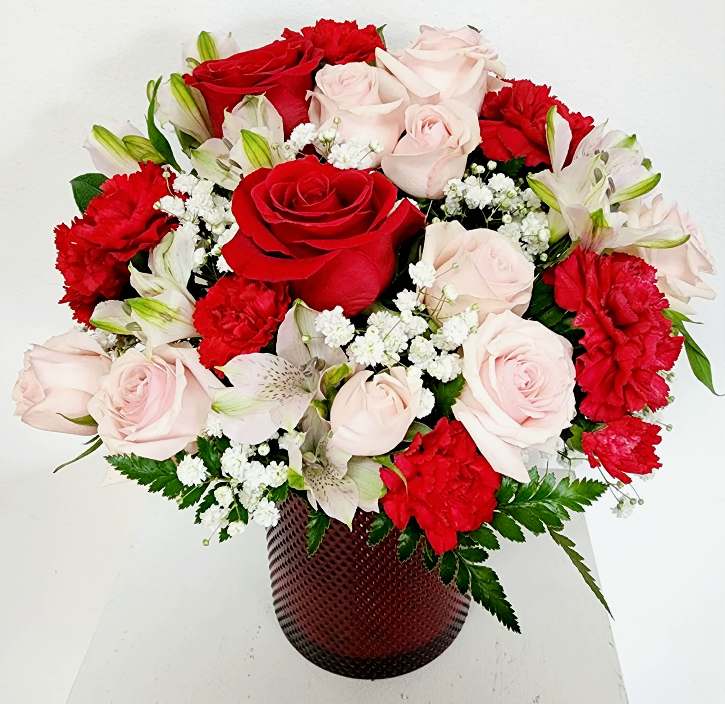 Date Night Bouquet  - This gift is perfect accent to a dinner table or her desk at work.  The red vase can be used as a glass votive for a candle after its floral use.  Red roses,  pink baby roses and alatromalstromeria  make this a bouquet an elegant gift