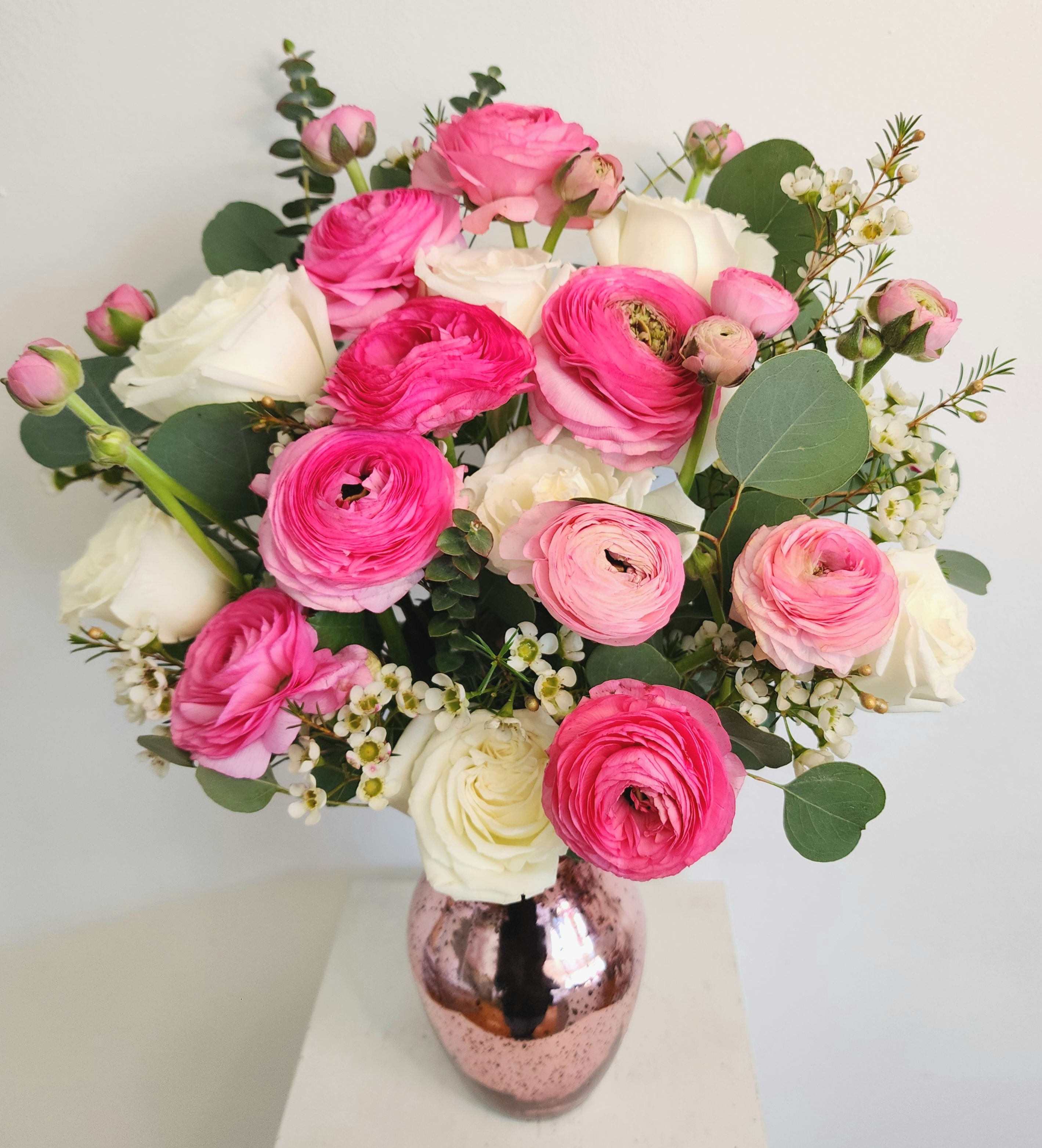 Ranunculus Soiree Bouquet  - Several stems of ranunculus with white roses or stock flower, and pink or white filler flowers in a pink mercury glass vase.  