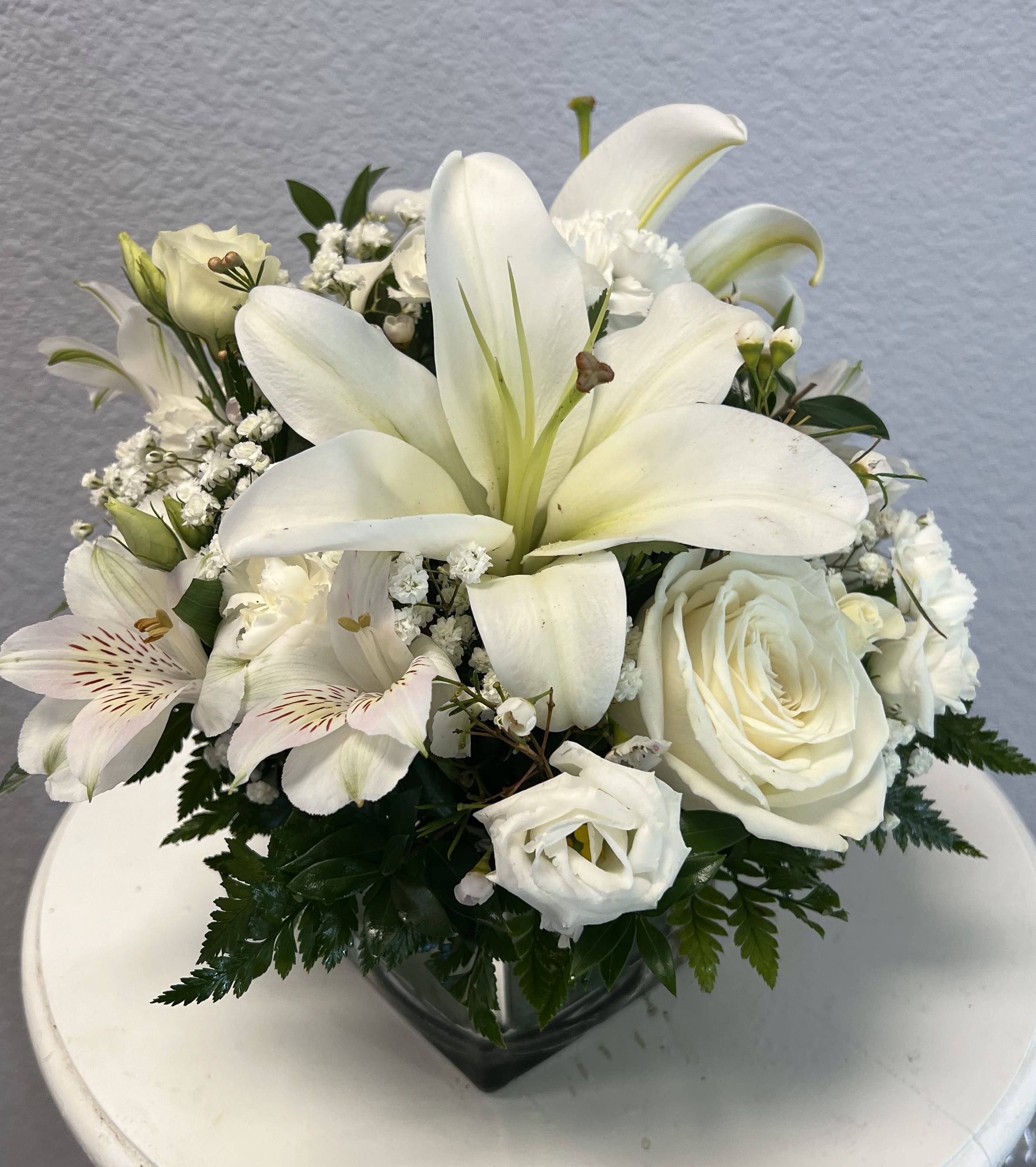 Timeless Elegance Bouquet - Our all white Timeless Elegance Bouquet in a clear glass cube is perfect for any occasion. White flowers have a timelessness and elegance that's perfect for any occasion. Hand-gathered by our caring florists with touches of lush greenery.