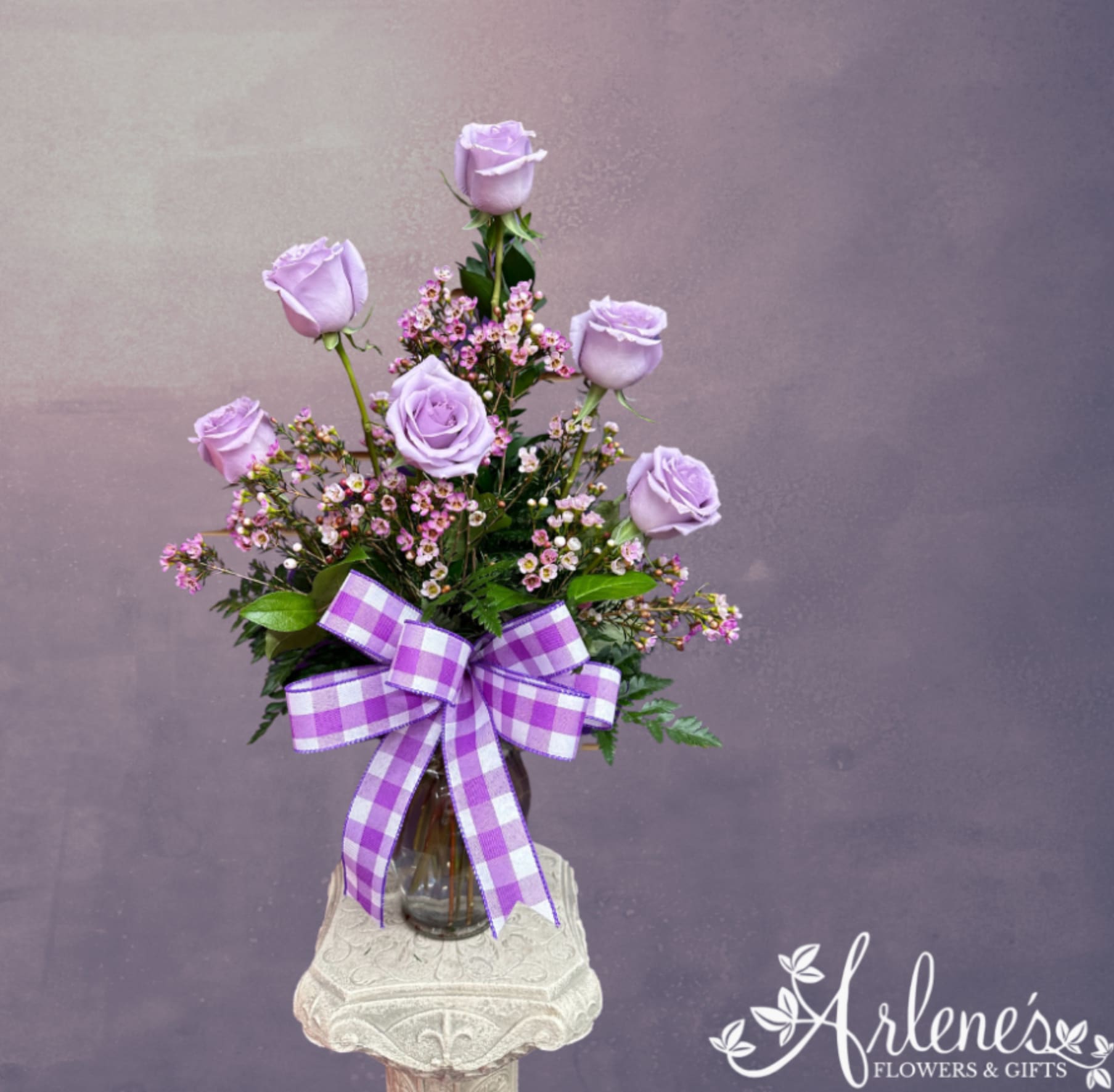 Half Dozen Lavender Roses - Six gorgeous purple roses arranged in a vase with filler, greenery and a bow. Shades will vary.
