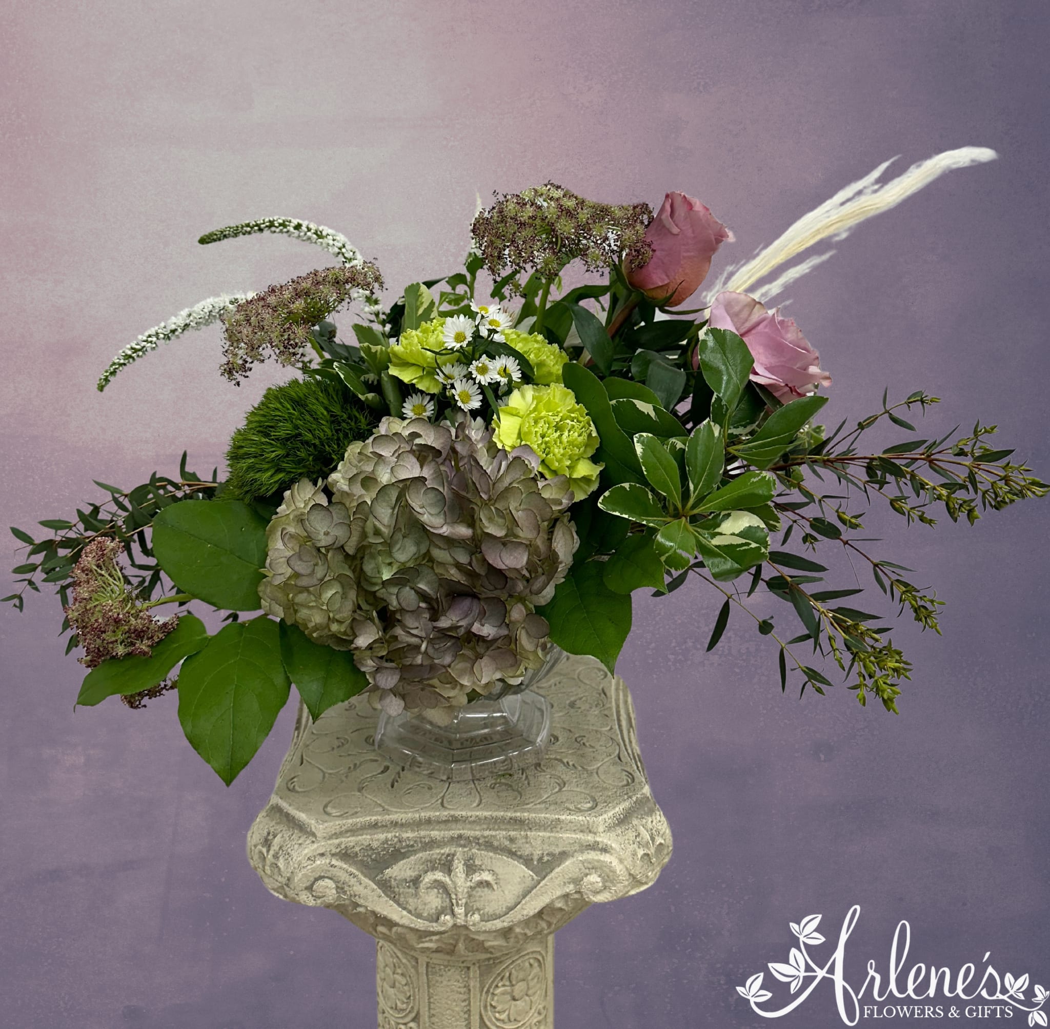 Antique Petals - Antique hydrangea, dried grasses, veronica, lavender roses and green carnations swirl around in an elegant all around pedestal vase.