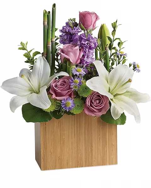 Kissed With Bliss by Teleflora - An elegant way to show you care, this bit of bliss blends luxurious lavender roses with wondrous white lilies into a stunning floral sculpture. Accented with exotic greens and presented in a modern bamboo rectangular vase, it brings natural serenity to any space. Includes lavender roses, white asiatic lilies, lavender stock, monte cassino asters and green chrysanthemums, accented with fresh greenery. Delivered in a large Bamboo Rectangular vase.  **Please note that The Holly Berry moves with the seasons, vessels, blooms, and foliage may vary from what you see in the photo. However, it will have the same beauty, uniqueness, and funky style. Please let us know in the florist notes if you have any color preferences or special requests, otherwise, we will make a tasteful decision for you! **  **Upgrade Notes: Please note that with each upgrade we will choose a mix of blooms, premium foliages, and filler to enhance your arrangement for the best presentation! 