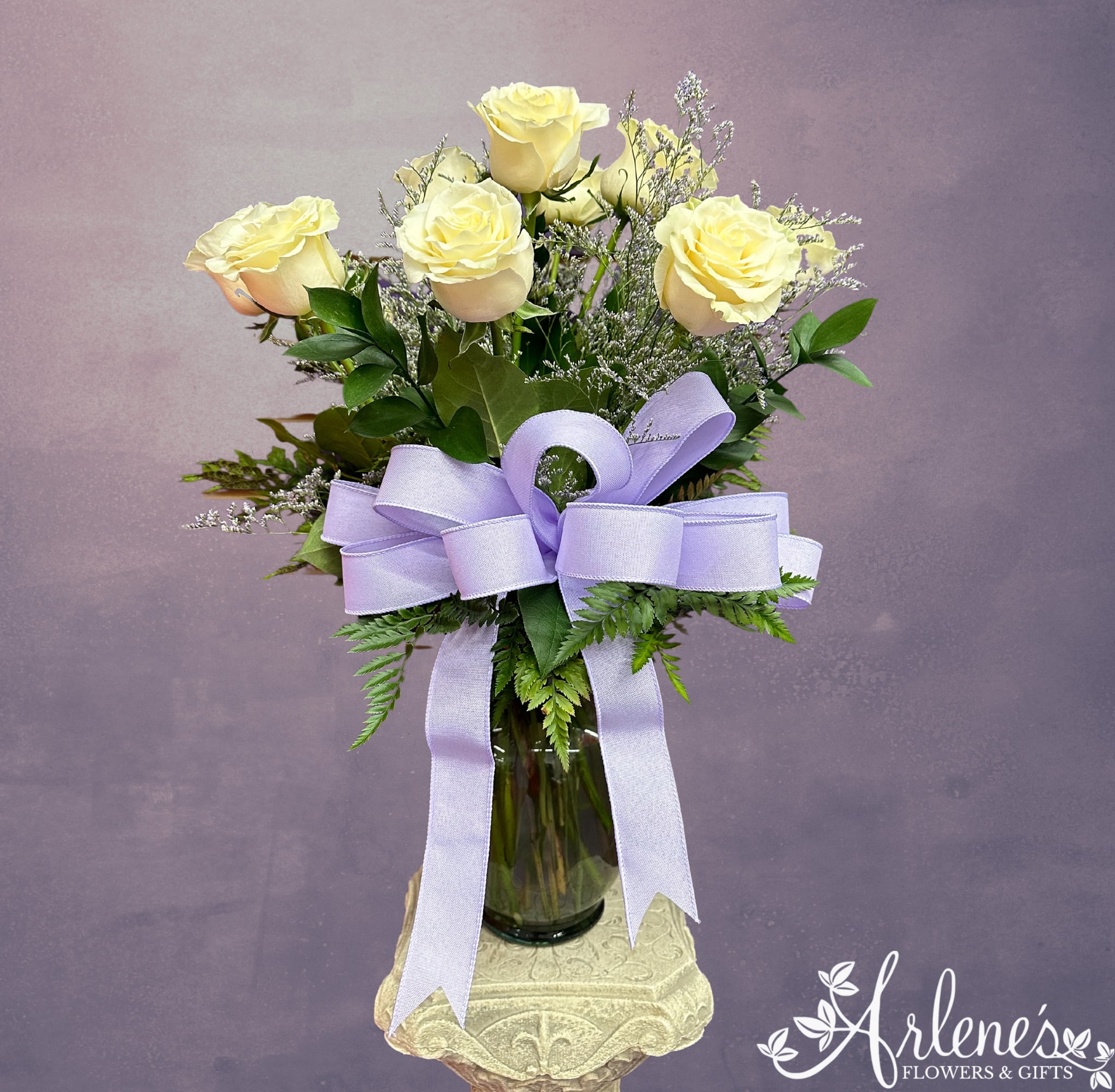 One Dozen White Roses - A traditional white dozen roses arranged with fancy greenery, filler flower and a beautiful bow.