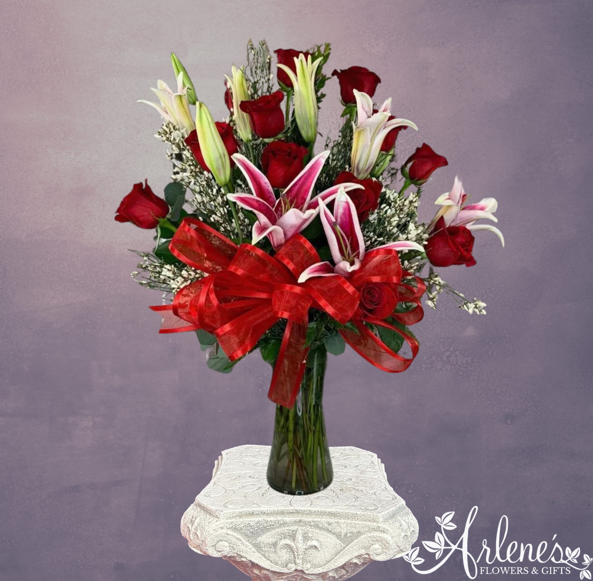 Dozen Rose and Lily  - A dozen red roses with stems of beautiful lilies (lily species may vary based on quality and availability). Starfighter lilies are shown. One of the most popular requests for Valentine's Day.
