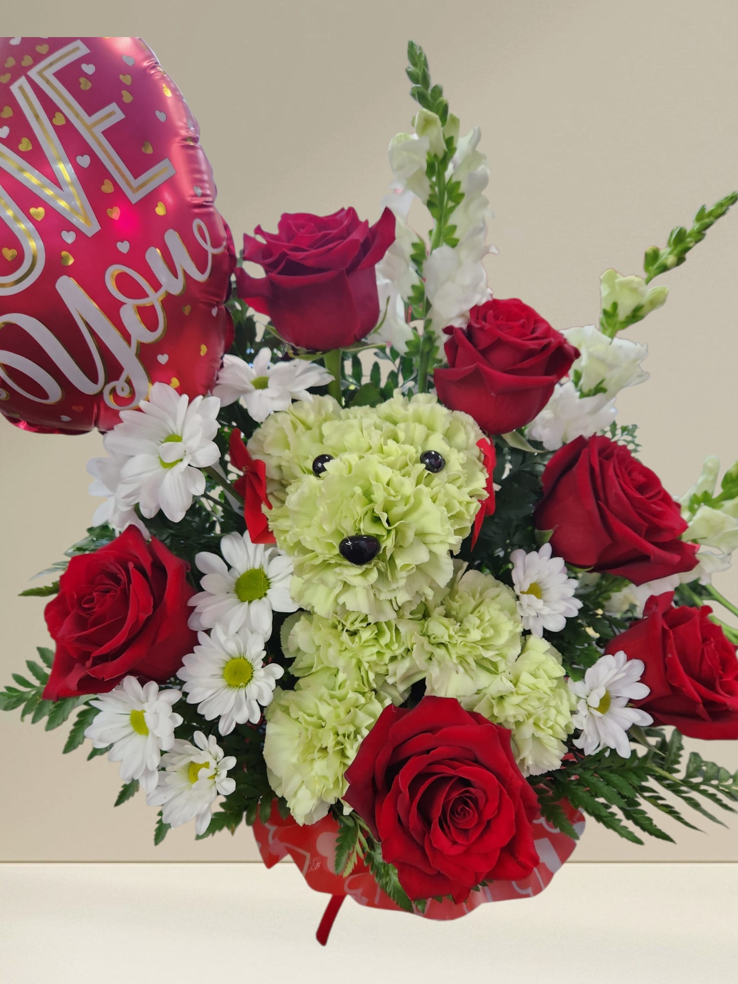 Dog Lover - Crafted from lasting carnation, our canine cutie is sitting pretty in a dog bed basket, surrounded by a mix of red, white daises  blooms. The perfect pick to spark romance or celebrate a special relationship.