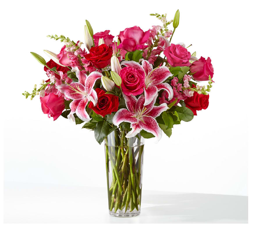 Always You Bouquet by FTD - Hot Pink Roses, Red Roses, Starfighter Lilies, Snapdragons with Greenery  in a Clear French Vase  SUBSITUTION POLICY In many instances, our photo may represent an overall theme or look and include a one-of-a-kind vase which cannot be exactly replicated.  Although the actual bouquet may not precisely match the photo, its temperament will. Occasionally, substitutions of flowers and/or containers happen due to weather, seasonality and market conditions which may affect availability. If this is the case with the gift you’ve selected, we will ensure that the style, theme and color scheme of your arrangement is preserved and will only substitute items of equal value or higher value.  If any design elements are of major importance to your order, please include them in the florist instructions at checkout or contact us to ensure availability.