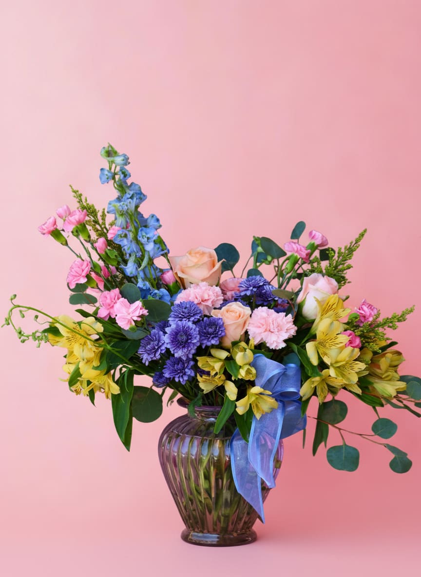 The Albena - A show stopping arrangement filled with a variety of brightly colored blooms. This is a designers choice arrangement meaning all flowers and colors will change. The vase will remain the same, but the vase color may also change due to availability. 