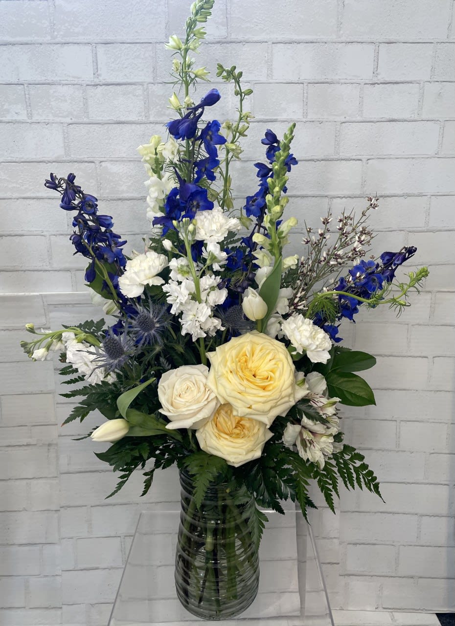 Beautiful in Blue - In this arrangement, the serenity of the color blue, along with the purity of intention symbolized by the white, will let the family know you are sending your calm strength during these difficult times. 