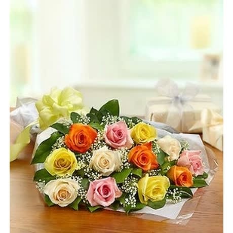 One dozen assorted color rose bouquet - 12 roses and greens wrapped presentation style. Standard version is shown. To add Baby's breath select deluxe version