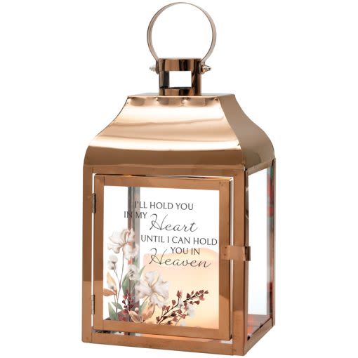 "In My Heart" Lighted Lantern - These lanterns are made with a high quality metal finish and uv printed glass artwork with sentiment. The flameless LED candle features a built in automatic timer 6 hours ON/18 hours OFF. 3 AAA batteries are included. These lanterns are intended for indoor use only. Comes with matching bow.   Choose deluxe if you would like to add a Silk arrangement on lid of lantern.  Lantern Reads: "I’ll hold you in my heart until I can hold you in Heaven" W: 6" H: 12.25" D: 4.5"