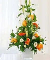 St Patricks Flowers of Ireland - Orange, green and white flowers, Roses, Lyzianthus and Liles presented in a glass vase One sided arrangement.  