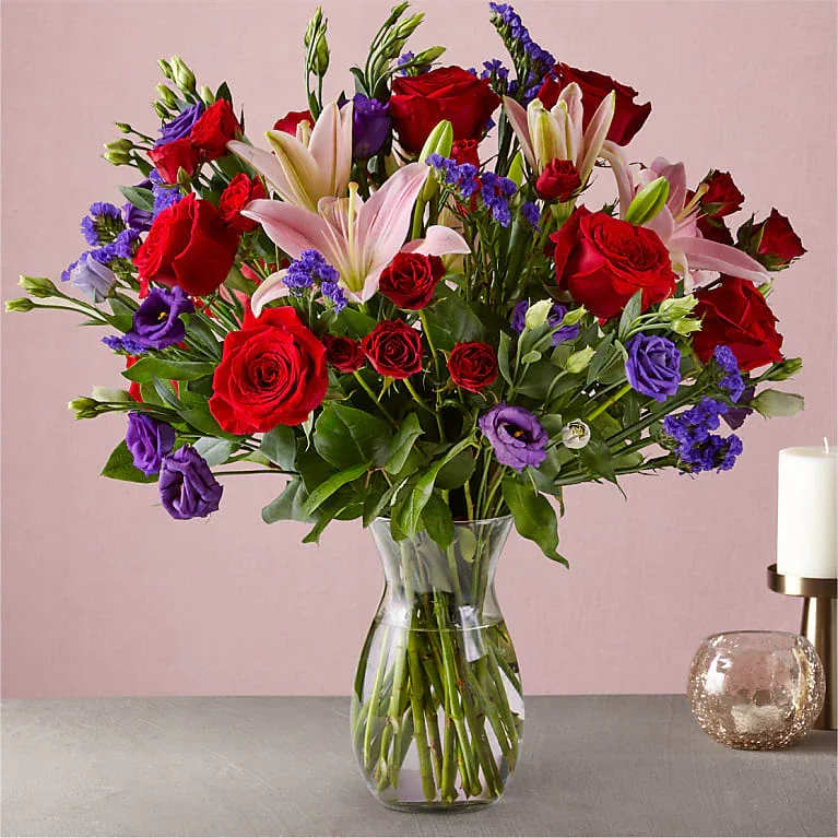 Amelie  - This dreamy jewel toned bouquet combines bold color and eye catching texture to make a statement. Featuring a thoughtful array of both roses and lilies, this dazzling assortment is bound to impress your recipient.  Crystal Clear Glass Vessel  Place your Order Online Monday to Saturday before 1:00 p.m. (E.T.) for same-day delivery. “Orders received after hours will be delivered the next business day”. Check our coverage area.  Occasionally, flowers and/or container substitutions happen due to weather, seasonality, and market conditions, which may affect availability. If this is the case with the gift you’ve selected, we will ensure that your arrangement's style, theme, and color scheme are preserved and will only substitute items of equal value or higher value.  CARE INSTRUCTIONS Keep the flower arrangement hydrated with natural water and change the water every two days. Do not spray any cleaning product on the flower arrangement. Do not place heavy objects directly on the flower arrangement. Keep flower arrangements out of direct sunlight and extreme heat. 