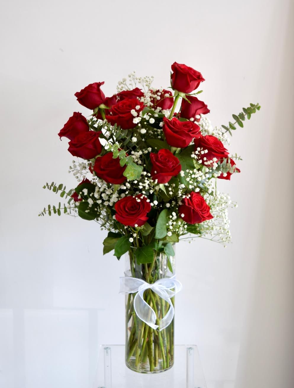 Timeless Romance  - A tall cylinder glass vase with roses, eucalyptus, and baby's breath.   Flower types may vary depending on the season.