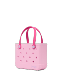 Bogg Bag Bitty - Pink Drink - Small but mighty. The Bitty Bogg Bag is our most compact tote—perfect for kids, snacks, small essentials, or even as a stylish lunch tote. It’s tip-proof, durable, and fully washable—just like our larger bags, but in a mini size made for quick trips and light hauls.  Great for Mommy &amp; Me moments or anyone who loves a grab-and-go option with serious charm.  Includes a small clear pouch for storing little essentials like keys, lip balm, or hand sanitizer.  Best for: Kids, lunches, snacks, small items, quick errands.