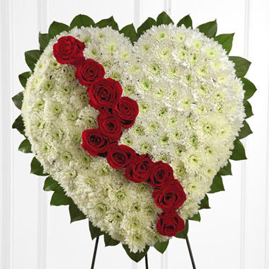 Broken Heart Funeral Tribute - This standing sympathy tribute has been popular for generations as a beautiful expression of both love and sorrow. The white full flower heart symbolizes heartfelt devotion, while the ‘broken’ line of red roses symbolizes loss or grief. Appropriate for wakes, funerals, and memorials. Approximately 20 to 24 inches wide as shown - consisting of white pom/poms with a line of broken red roses. 