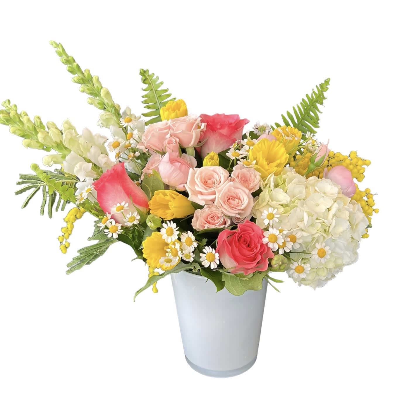 Daffodils &amp; Mimosa  - Daffodils, white hydrangea, pink spray roses, pink roses, pink ranunculus, white snap dragons, fern and filler flower designed in a white glass vase. 