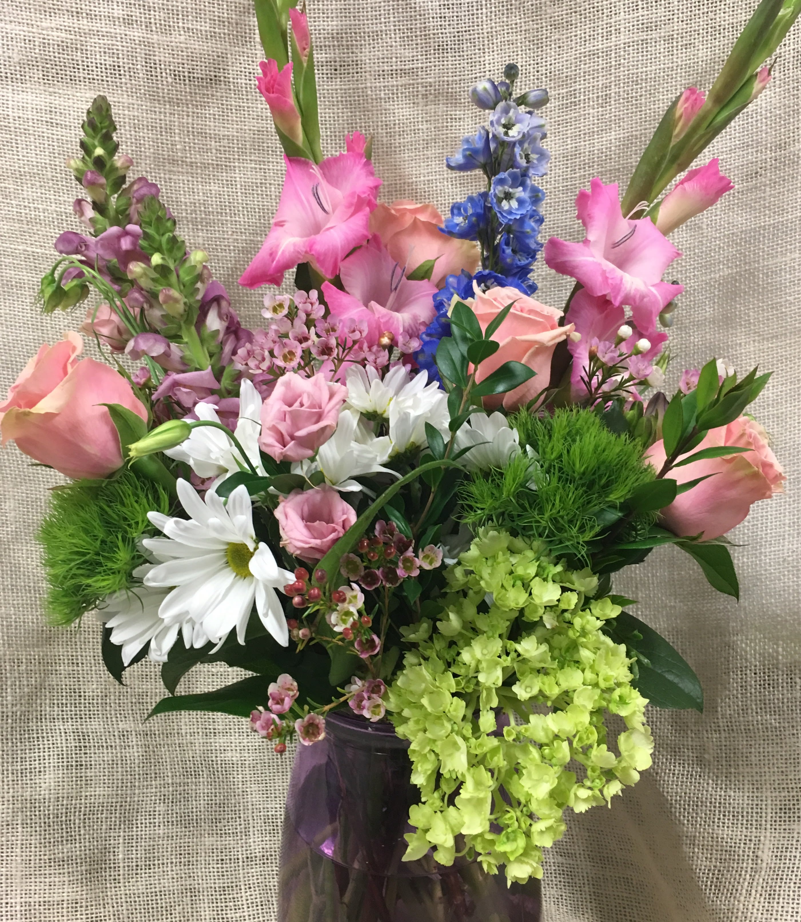 Softly Spoken - Pastel Blooms with Green and White accents - She loves the soft colors and this is one she will love.  This bouquet is a stunner, perfect for birthdays, sympathy-- or to cheer someone up. Beautiful blooms in pinks and purples should bring a smile for your thoughtfulness.  Click Through for a variety of samples of this design!