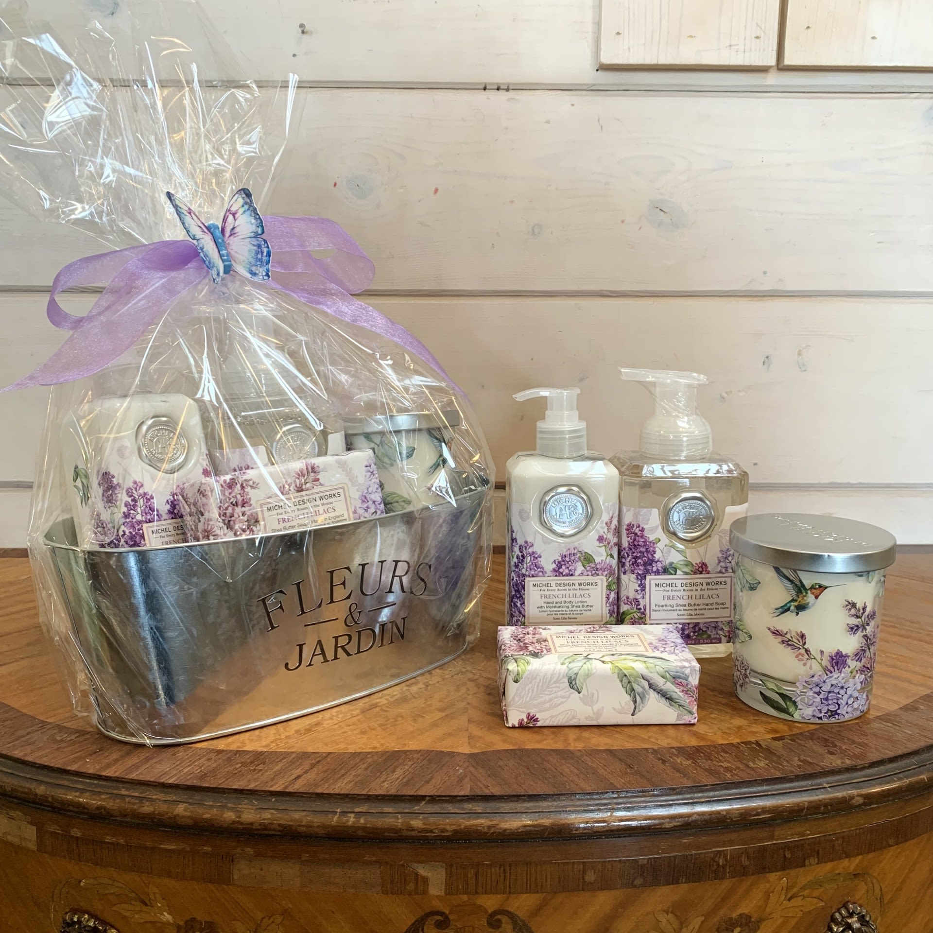 French Lilac Deluxe Gift Basket - This large gift basket includes one hand and body lotion, one scented decorative candle, one foaming hand soap, and one large bar soap. Beautifully wrapped up and ready to go with a large bow.  Fragrance: lilac blooms  Items included: 1) Our soothing lotion is a blend of aloe, coconut oil, shea butter, and other select herbs and botanicals to moisturize and soften the skin. 12 fl oz / 354 ml  2) Our all-natural, decorative jar candle is nontoxic, biodegradable and clean burning, made from a sustainably sourced soy and palm oil wax blend. 7.4 oz/209 g 38 hrs. approximate burn time  3) Our foaming hand soap contains luxurious shea butter and aloe vera for gentle cleansing and moisturizing. 17.8 fl. oz. / 530 ml liquid  4) Our triple-milled soap is silky smooth and long lasting, and contains the finest pure palm oil, glycerin, and rich shea butter. Made in England. 6.7 oz / 190 g  Customizable gift baskets available upon request. Please give us a call at 775-348-6161 for assistance putting together the perfect aromatherapy basket for your loved one.