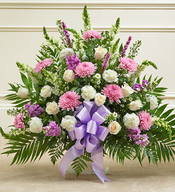 Tribute Lavender &amp; White Floor Basket Arrangement - Expressing all the love you feel in your heart during times of loss is not always easy. This delicate floor basket arrangement helps you convey your care and concern with beautiful lavender flowers to represent a vibrant life, and fresh, white blooms to symbolize purity and peace.