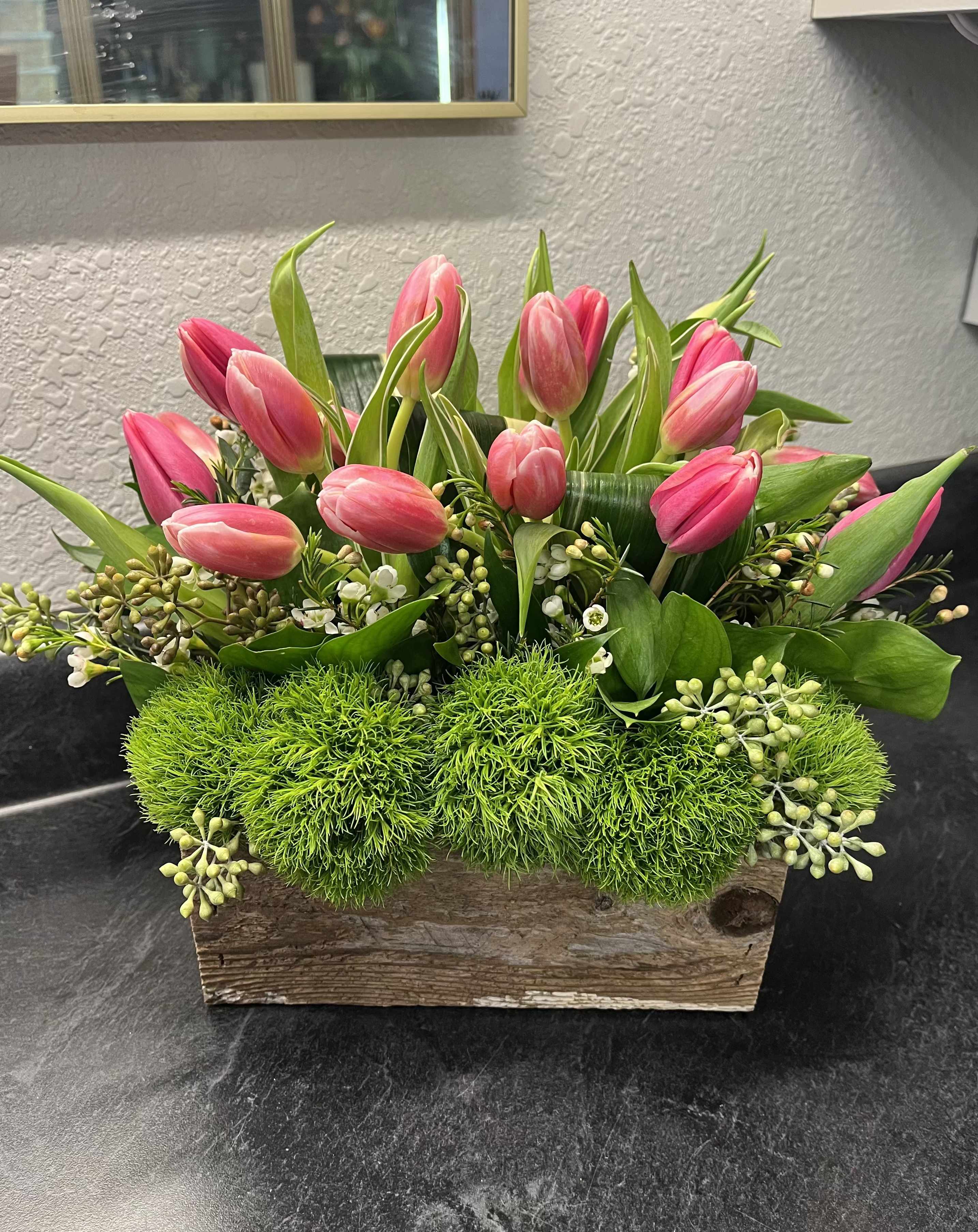 Tulip Garden - A perfect design to welcome spring and new beginnings.  This design is sure to brighten the receiver's day! Including Pink Tulips, Green Trick, and mixed Daisies.  