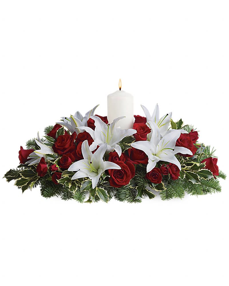 Luminous Lilies Centerpiece - Fragrant and fabulous, this luxurious floral centerpiece is sure to earn "oohs" and "aahs" at your family get-together! Stunning white asiatic lilies hint of freshly fallen snow against lush greenery and stunning red roses. Classic colors and holiday cheer are echoed in this beautiful centerpiece of red roses, white asiatic lilies, noble fir and holly branches. A single white pillar candle adds subtle glow.