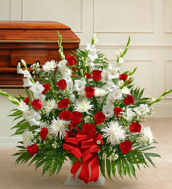 Tribute Red &amp; White Floor Basket Arrangement - When you just can’t seem to find the words, let this touching arrangement help you express your deepest condolences, which is customary to send to the funeral home, this tasteful gathering lets you express all the emotion you have in your heart at this difficult time. With red blooms to symbolize love and white blooms to symbolize respect, it’s a truly beautiful way to let friends and loved ones know how much you care
