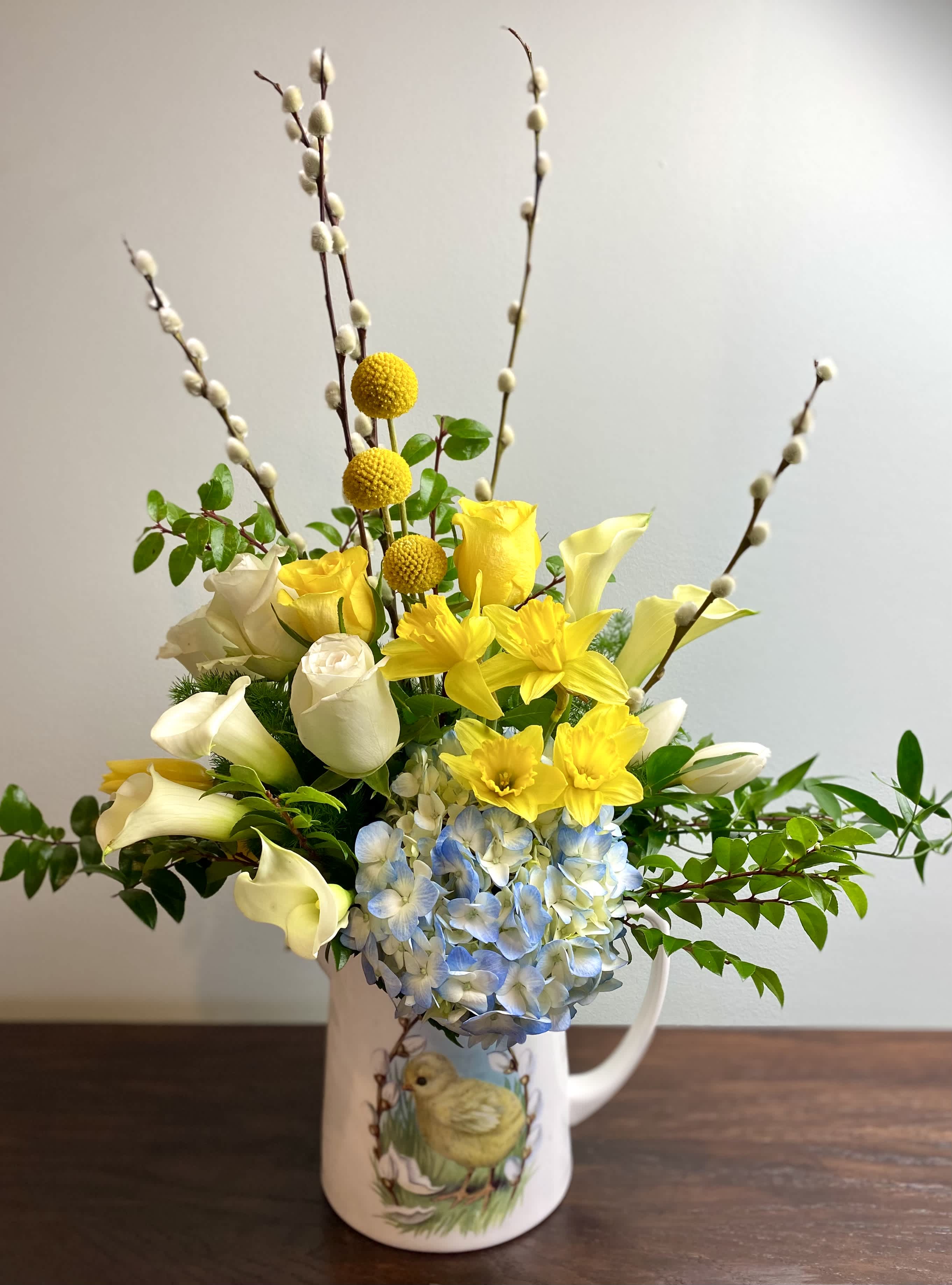 Easter Morning - A cheery Spring design perfect for an Easter celebration or day brightener.  Includes Yellow Daffodils, Yellow Roses, White Roses, Yellow Tulips, White Tulips, White Calla Lillies, Yellow Billy Balls, Pussy Willow, and a Blue Hydrangea with mixed greens.  *Ceramic Vase or Pitcher may vary. 