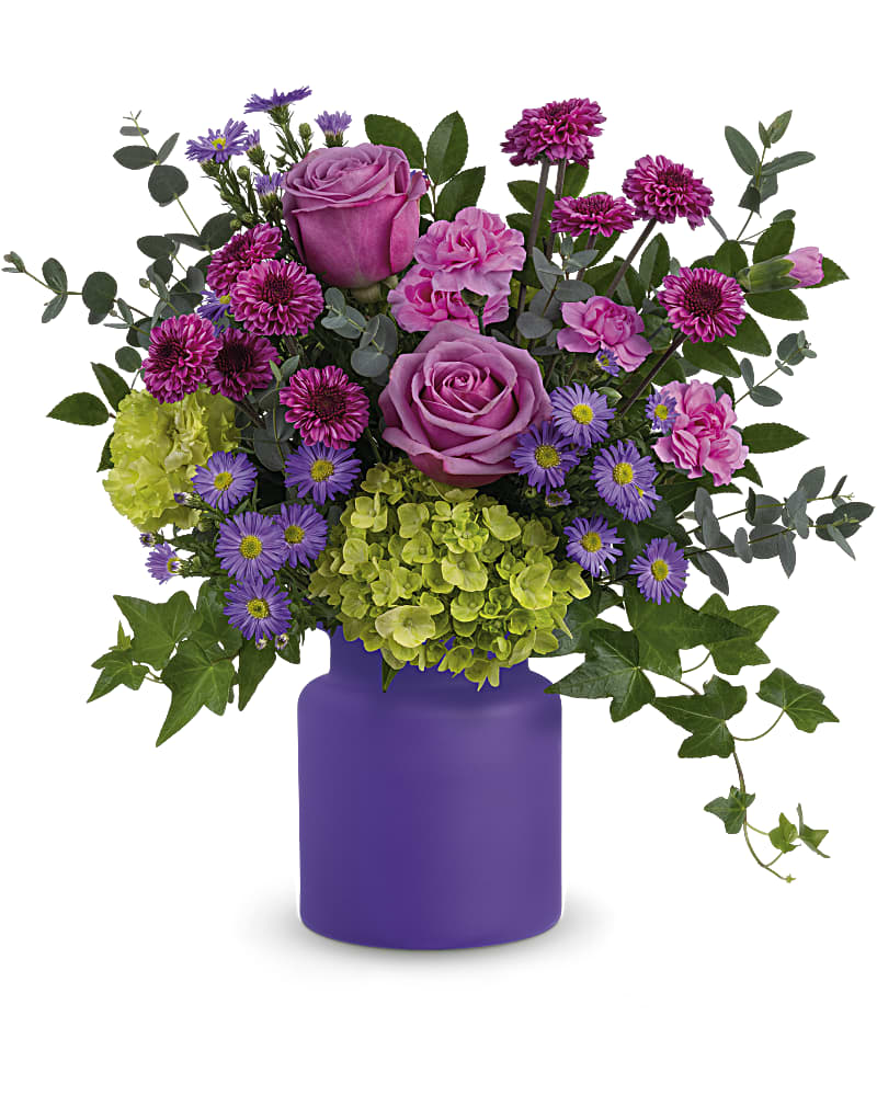 Teleflora's Amethyst Awe Bouquet - Everyone's in awe of this breathtaking bouquet! Roses, asters and hydrangea are presented to perfection in an amethyst-hued, frosted glass jar. Lavender roses, large purple monte cassino asters, miniature green hydrangea, purple button spray chrysanthemums, green carnations and miniature pink carnations are arranged with parvifolia eucalyptus, green ivy and huckleberry. Delivered in Teleflora's Savannah Jar.