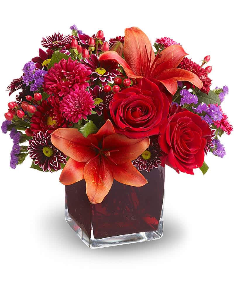 Teleflora's Autumn Grace - Roses, lilies and asters in precious gemstone colors of garnet are nestled into a richly colored plum glass cube vase, creating a graceful presentation. Purple chrysanthemums and seafoam statice add a special touch. A beautiful bouquet for any occasion! Red roses, Asiatic lilies, Matsumoto asters and hypericum; purple daisy spray chrysanthemums and seafoam statice are delivered in a plum glass Teleflora cube vase.Approximately 11" W x 10" H