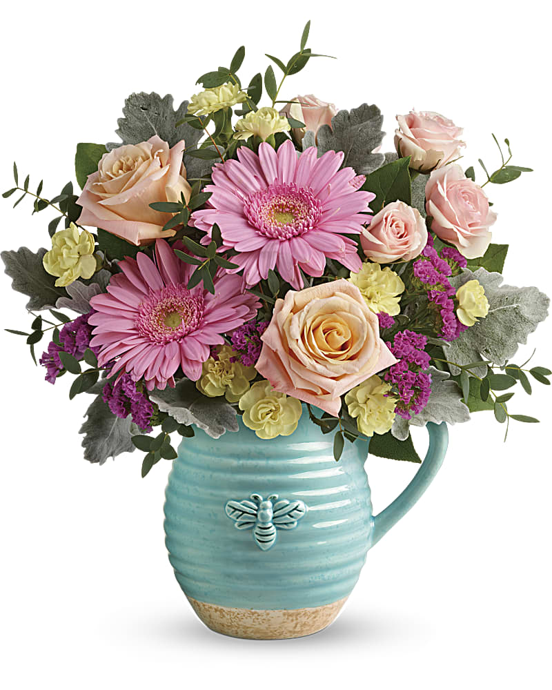 Teleflora's Bee Delighted Bouquet - This delightful bouquet includes peach roses, pink spray roses, pink gerberas, yellow miniature carnations, raspberry sinuata statice, parvifolia eucalyptus, dusty miller, and lemon leaf. Delivered in a Busy Bee pitcher. Who could help but "bee delighted" by this sweet surprise! Bursting with spring-fresh pink and peach blooms, this charming country-inspired ceramic pitcher is sure to be a favorite food-safe keepsake!