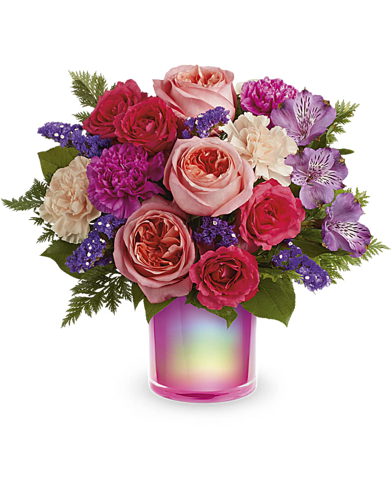 Teleflora's Feeling Magical Bouquet - Turn on the magic with this shimmering, iridescent fuchsia vase, filled with a fabulous rose bouquet. This bouquet features peach roses, dark pink spray roses, purple alstroemeria, hot pink carnations, peach carnations, purple sinuata statice, leatherleaf fern and lemon leaf. Delivered in a Magical Muse Cylinder.