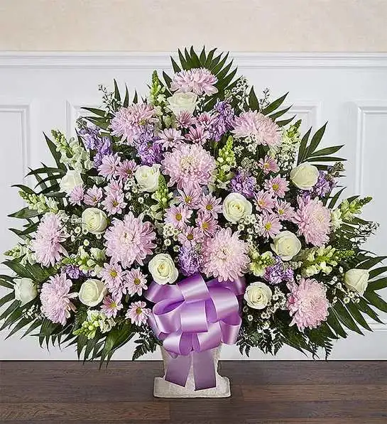 Heartfelt Tribute.Lavender &amp; White Floor Basket - In times of loss, expressing the love you feel in your heart is not always easy. Our elegant floor basket arrangement in graceful hues, handcrafted by our caring florists with soothing lavender and white blooms, is a tasteful gesture perfectly suited for the funeral home or memorial services.Floor basket arrangement of lavender daisy poms, football mums, and stock; white roses, snapdragons and monte casino; accented with soft, lush greenery