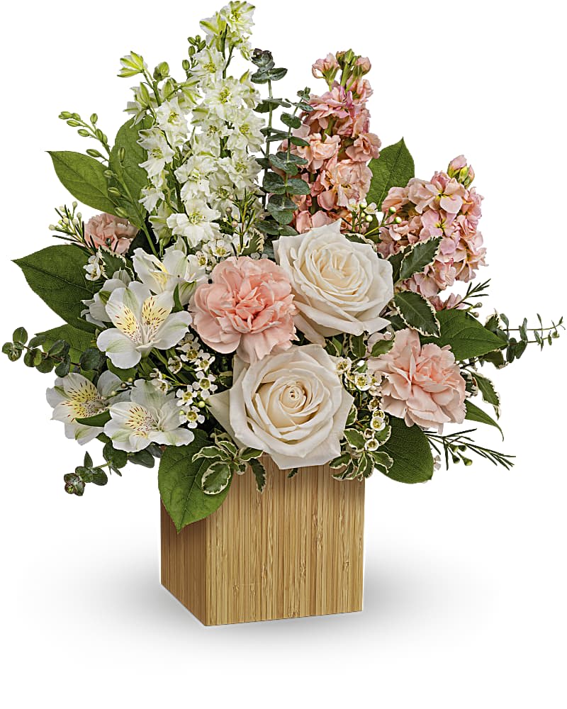 Teleflora's More Adored Bouquet - Artfully arranged in a sleek, eco-friendly bamboo cube, this whimsical bouquet of creamy blooms is the essence of adoration. CrÃ¨me roses, white larkspur, peach stock, white alstroemeria and white waxflower are arranged with variegated pittosporum, lemon leaf and spiral eucalyptus. Delivered in a Small Bamboo Cube.