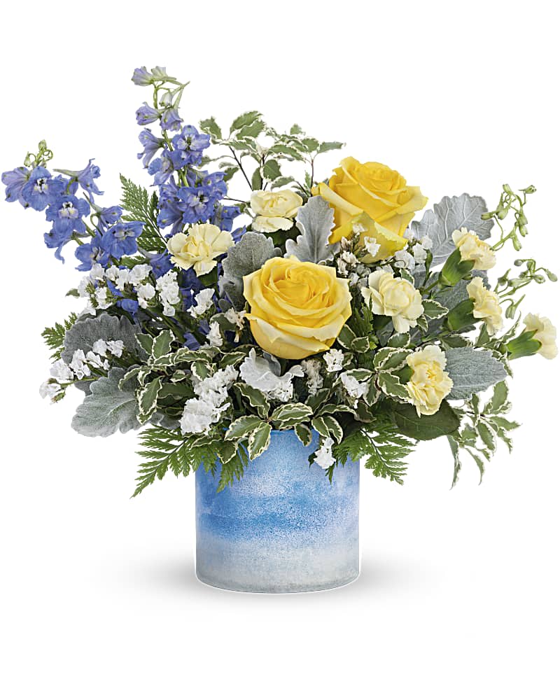Teleflora's Seaside Dreams Bouquet - Like a stroll by the sea, this radiant yellow rose bouquet in an ocean-inspired art glass vase delights the senses. This dreamy bouquet includes light yellow roses, miniature light yellow carnations, blue delphinium, white sinuata statice, dusty miller, pitta negra and leatherleaf fern. Delivered in a Color Frost Art Glass cylinder.