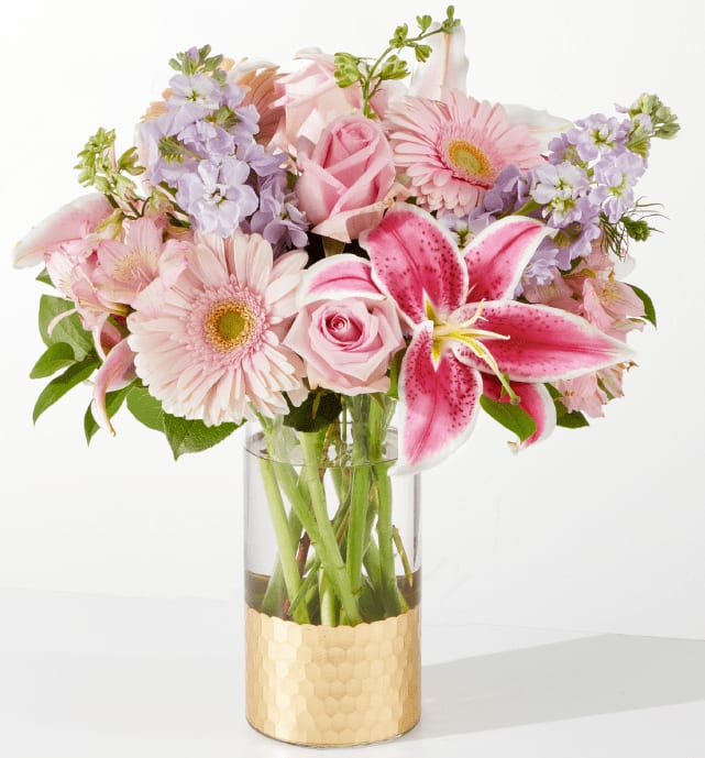 The Teahouse Bouquet - An arrangement of roses, gerbera daisies, stock, larkspur, alstroemeria, and starfighter lily arrangement in a gold dipped vase.
