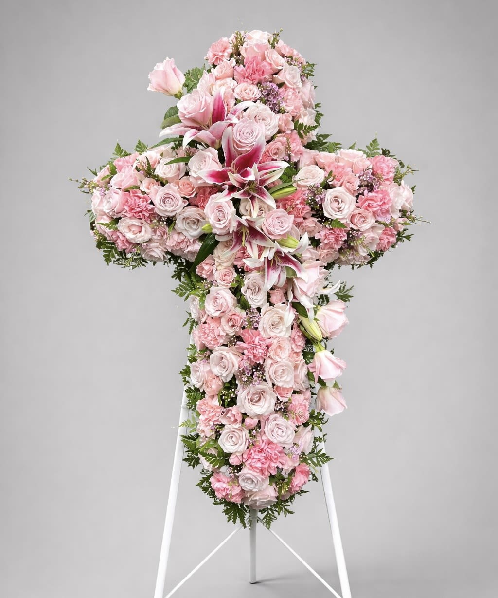 In Our Thoughts - The Pink Cross Standing Spray is a beautiful tribute designed to offer comfort and convey respect. Crafted with precision and care, this floral arrangement features a harmonious blend of delicate pink blooms that symbolize love and grace. Perfect for memorials and services, it stands as a poignant reminder of peace and serenity.