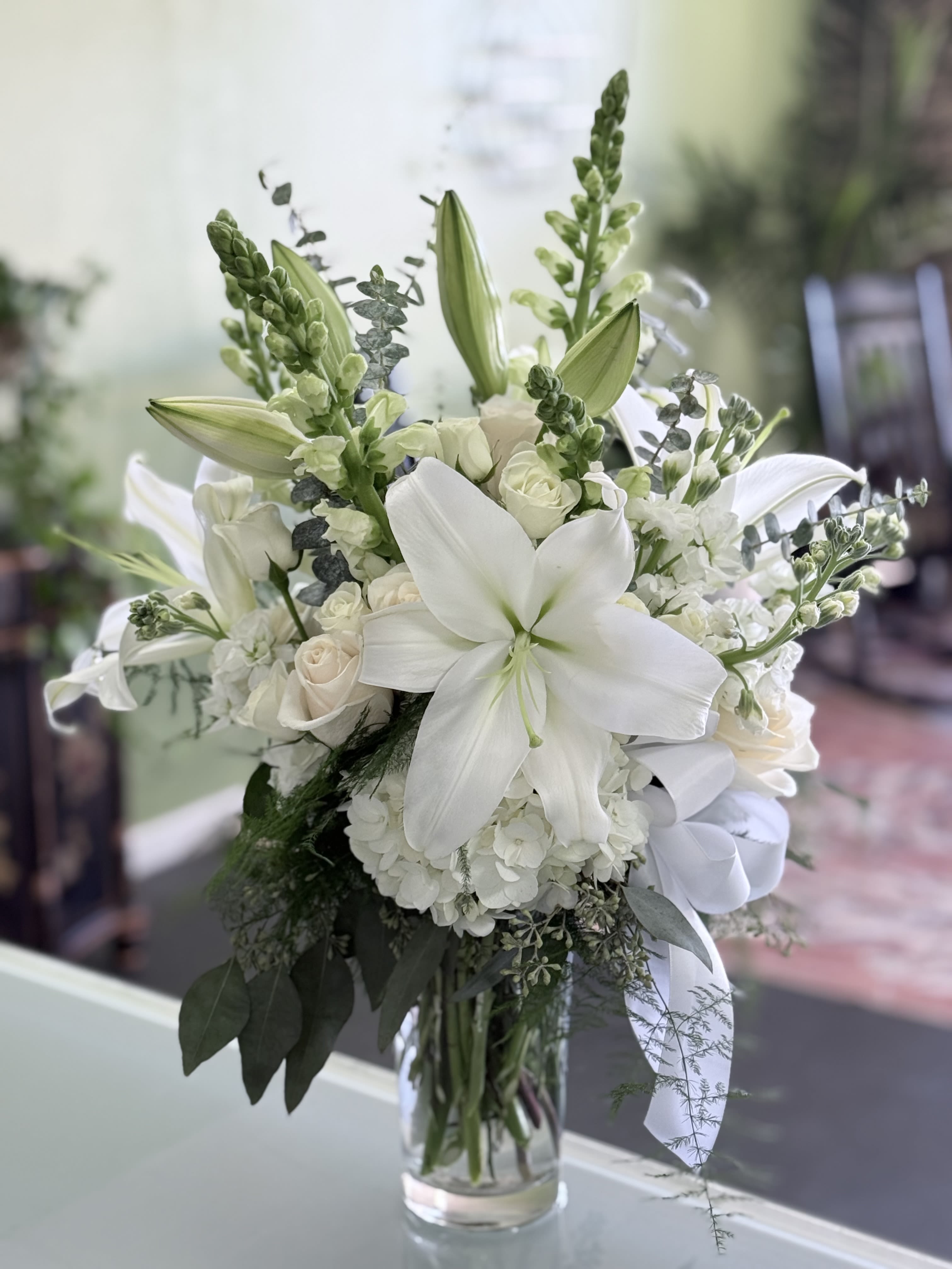 White lily and rose bouquet in a clear glass vase