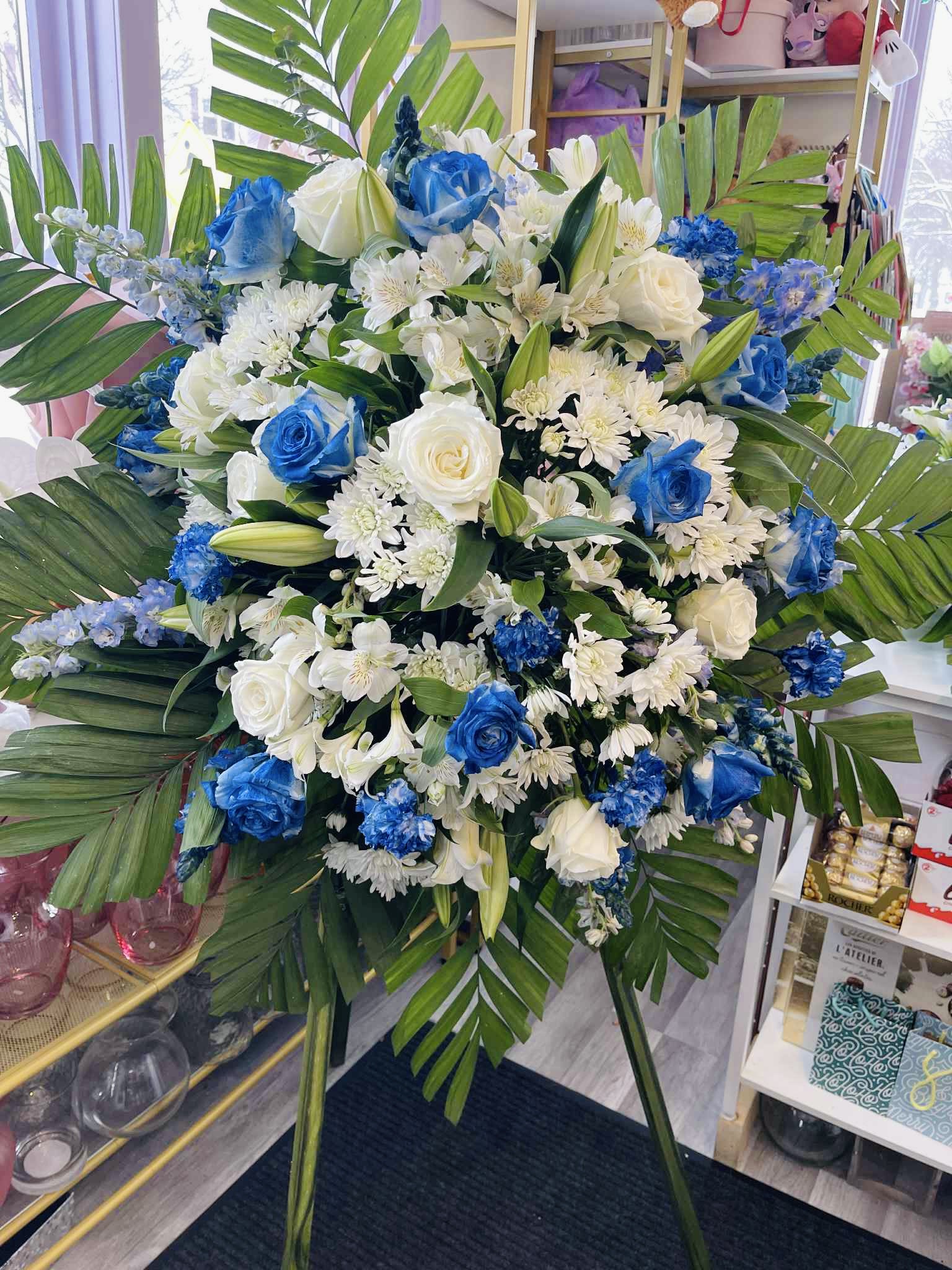 Blue Sympathy Standing Spray - A classy and elegant floral sympathy standings pray, with white carnations, royal blue roses, and snapdragons  Hand arranged by a florist this is a classic gift to send to honor a loved one,  if you like a different color of flowers let us know, on the box of instructions for the florist, or call me at 6127570069 for any modifications or questions.  
