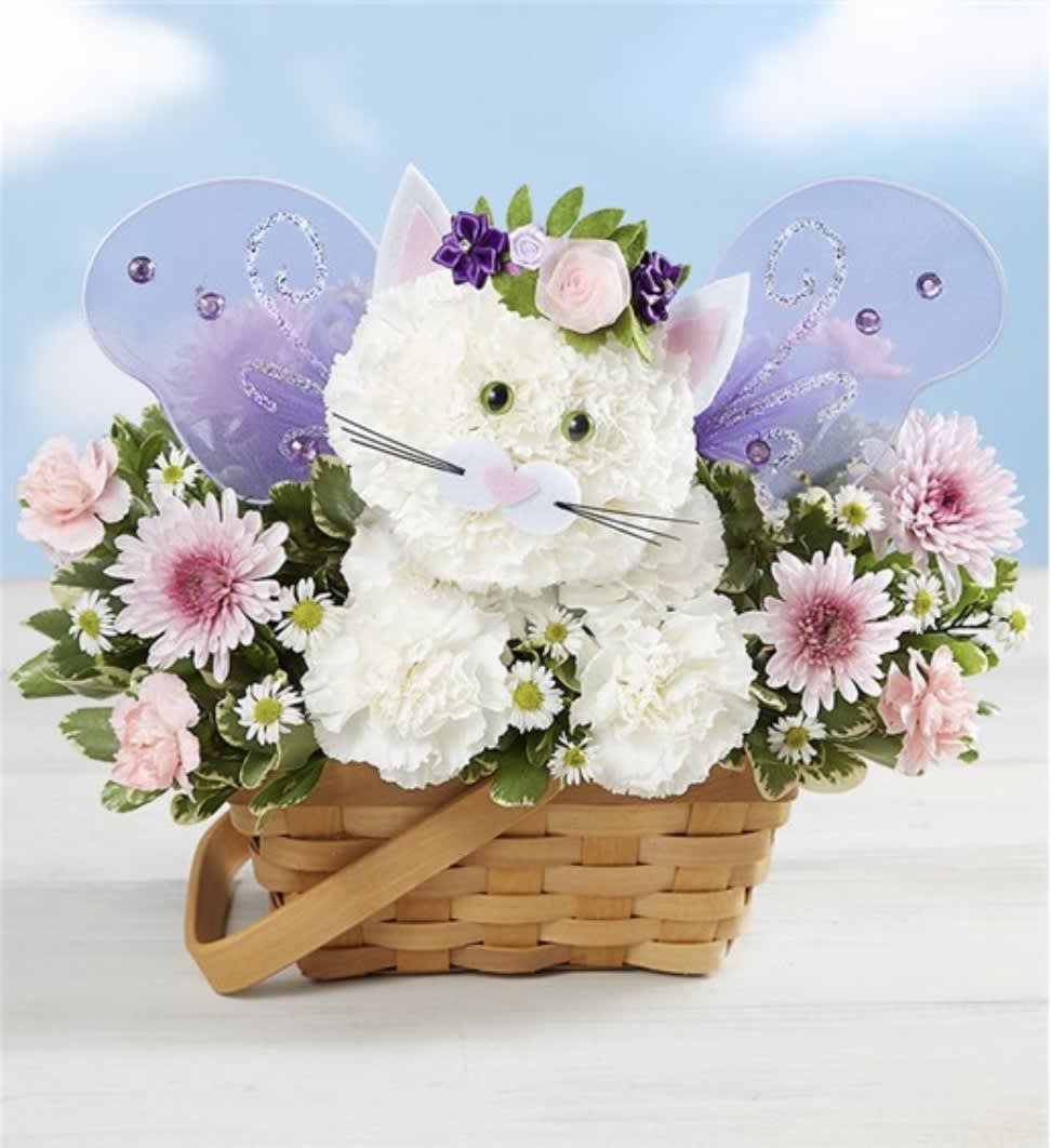 Magical Fairy Cat - A magical day is just a fairy cat away! Our fantastical feline is artistically crafted with a mix of white, pink and lavender blooms. Featuring a sweet flower crown and glittering, rhinestone-adorned wings, this unique and enchanting 3D creation brings whimsical fun to everyone. • One-sided 3D arrangement with white carnations and monte casino, pink mini carnations and lavender cushion poms; accented with assorted greenery • Crafted in the shape of a cat, complete with eyes, nose, flower crown and glittery purple wings decorated with rhinestones • Arrangement measures approximately 11.5""H x 12""W • Artistically designed in a dog bed basket accented with sheet moss; measures 7""D • Our florists hand-design each arrangement, so colors, varieties and container may vary due to local availability"