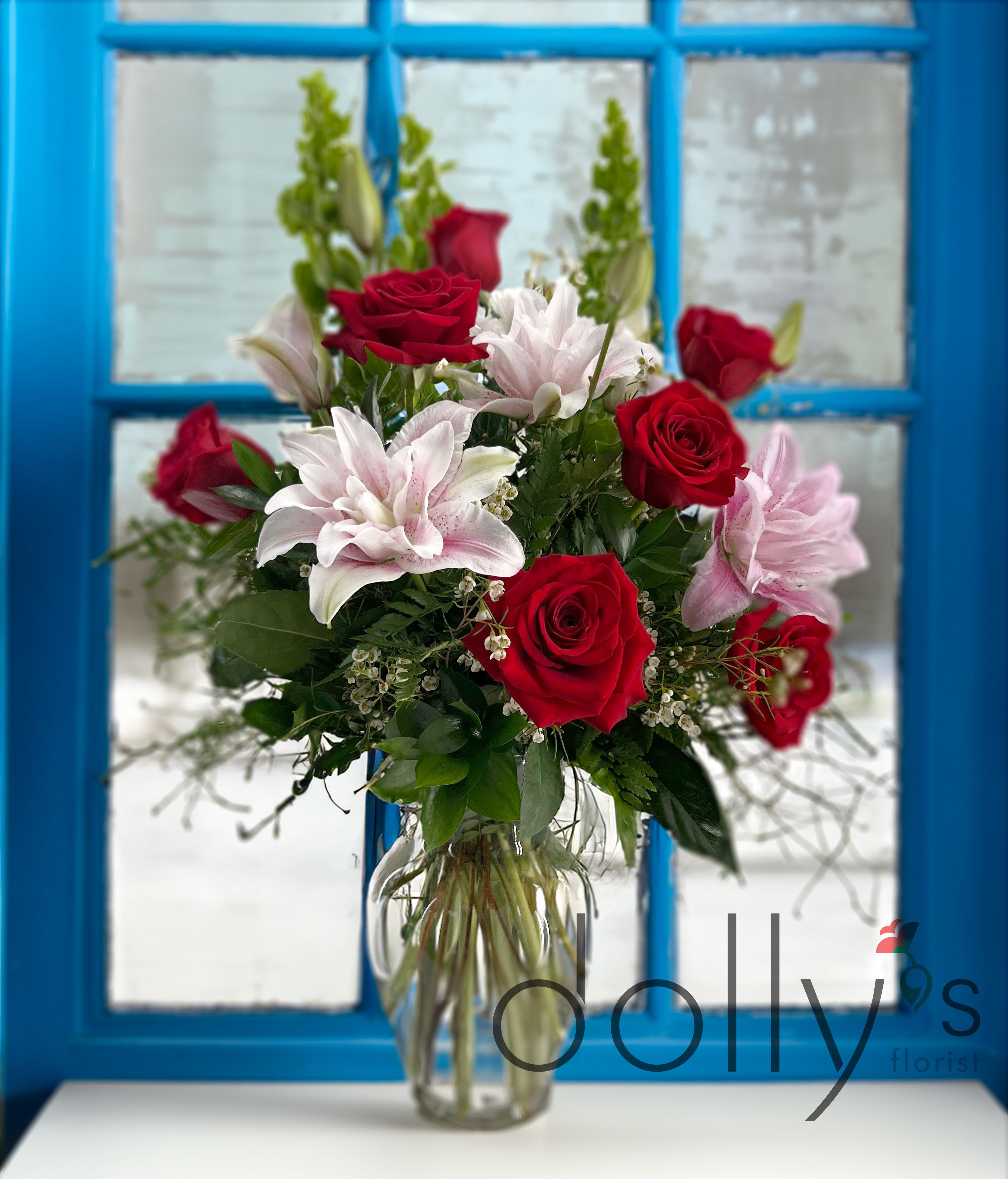 Red roses and pink lilies in a clear glass vase