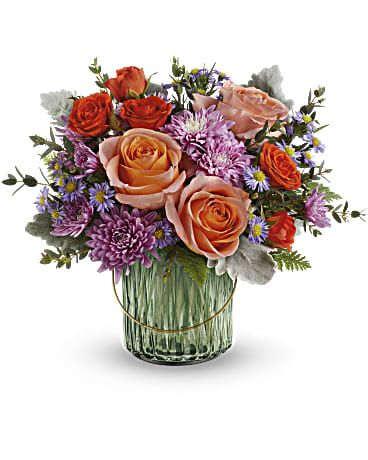 Bouquet of peach and orange roses with purple flowers in a glass vase