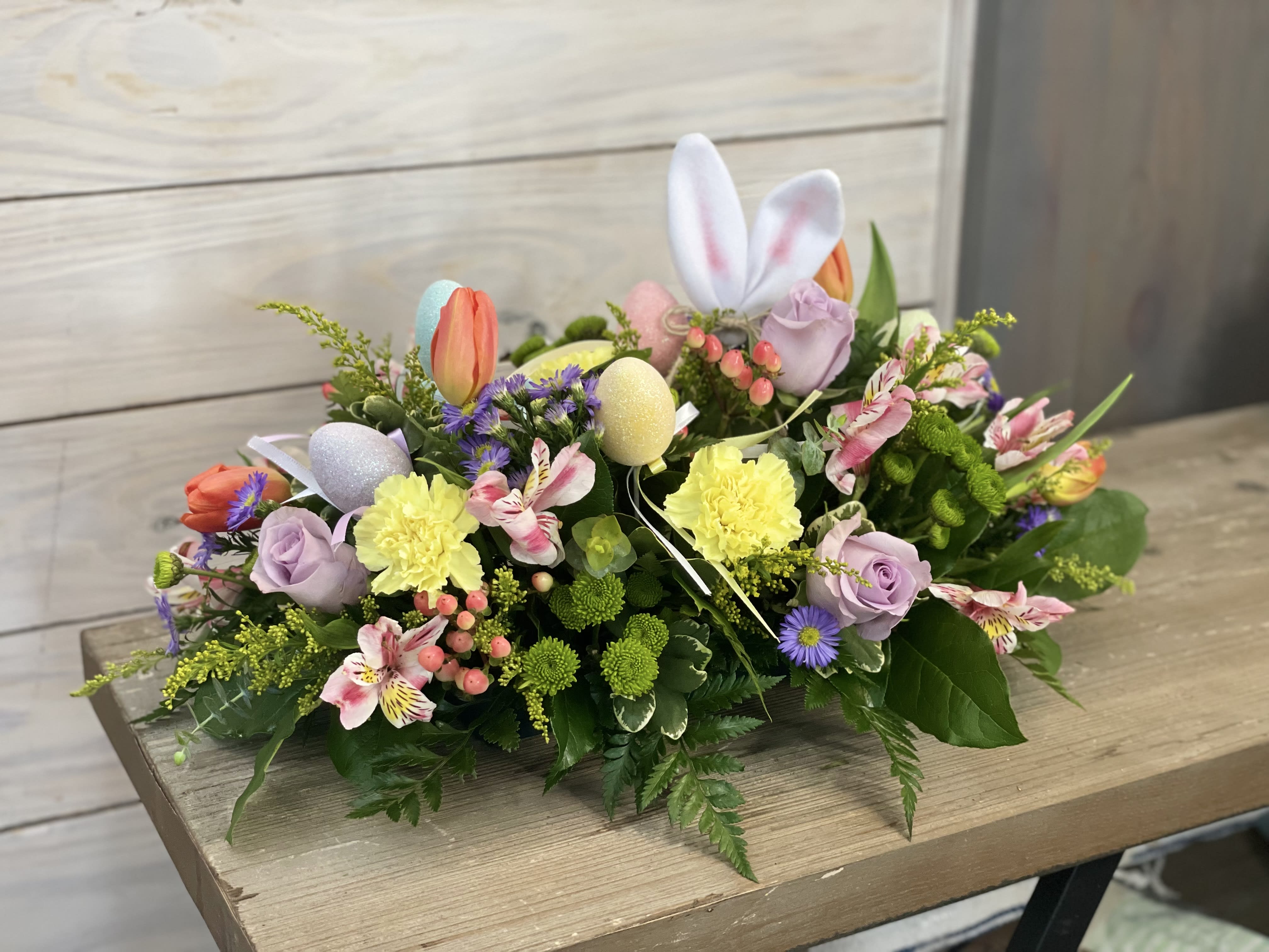Easter floral arrangement with pastel flowers and decorative eggs
