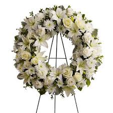 White Grace - A ring of fragrant bright white blossoms will create a serene display at any funeral or wake. This classic wreath is delivered on an easel and is a thoughtful expression of sympathy and admiration. A standing wreath created from fresh white flowers such as roses Asiatic lilies carnations and cushion spray chrysanthemums - accented with greenery - is delivered on an easel.Approximately 22" W x 22" H Orientation: One-Sided As Shown : DG239-3A